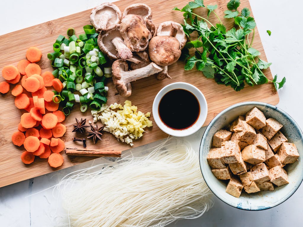 Vibrant assortment of fresh vegetables, herbs, and tofu for an authentic Asian meal preparation.