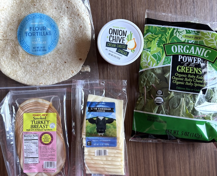 these spinach turkey cream cheese rollups are made using just 5 ingredients which are pictured here - flour tortillas, cream cheese, sliced turkey breast, cheese slices, and spinach