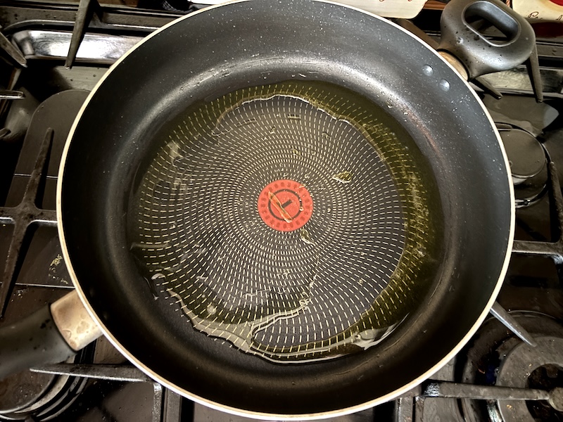 Adding olive oil to skillet