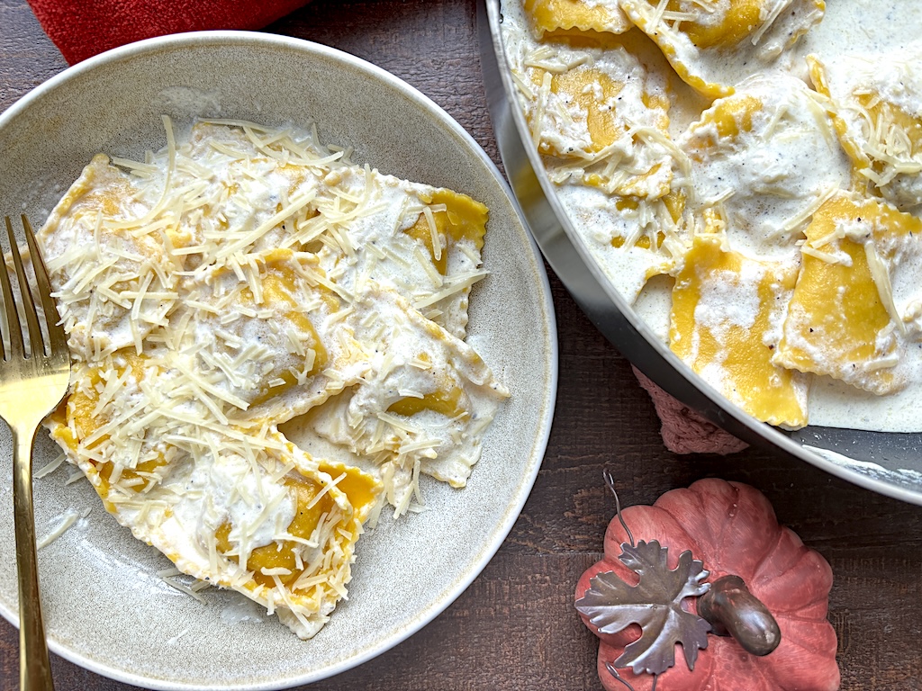 A plate of the butternut squash ravioli with cream sauce that's ready to eat! 