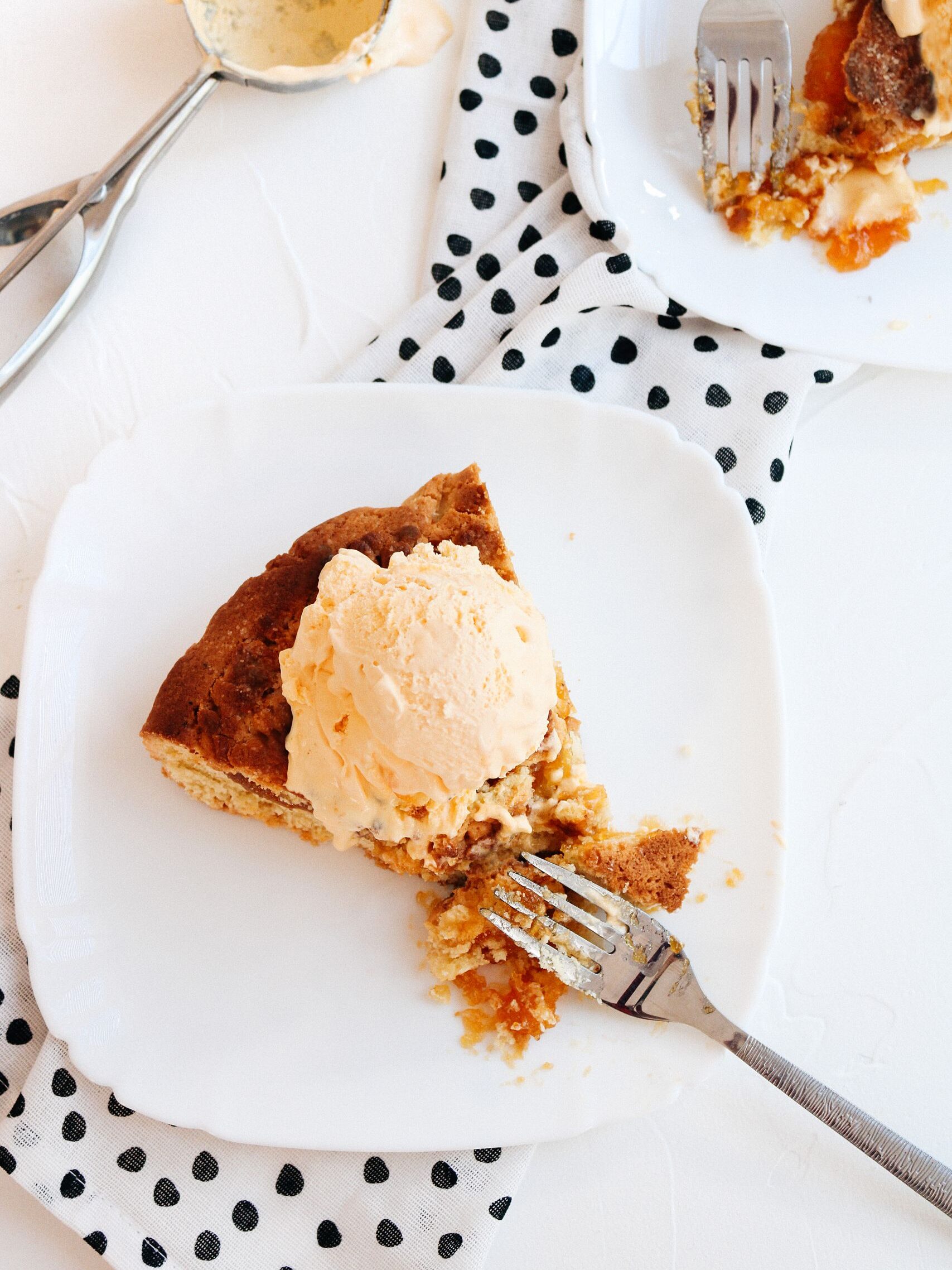 Delicious pumpkin pie topped with ice cream served on a ceramic plate. Perfect dessert scene.